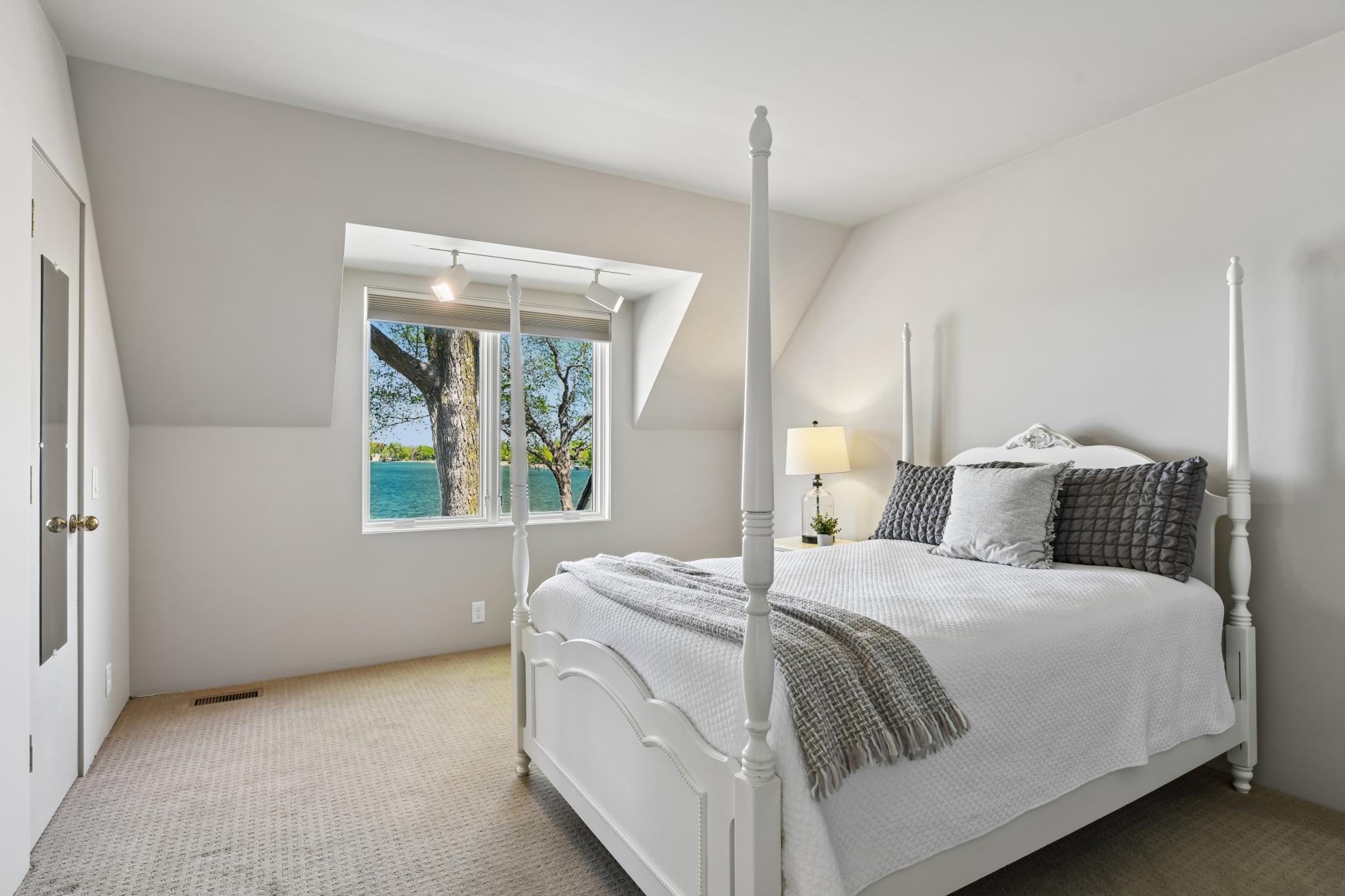 One of two upper level bedrooms offering lake views, built-in bookshelves and a wall closet.