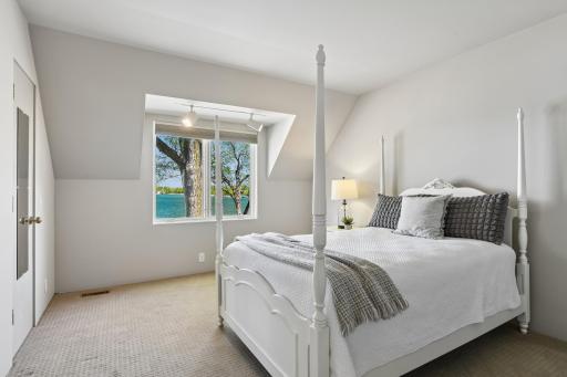 One of two upper level bedrooms offering lake views, built-in bookshelves and a wall closet.