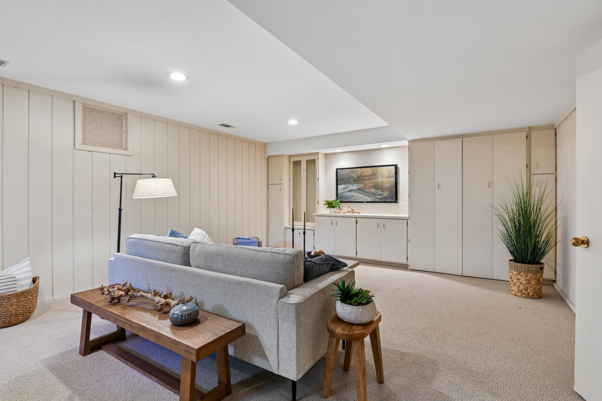 A wall of built-ins fill one wall offering locked storage, a media area and murphy bed.