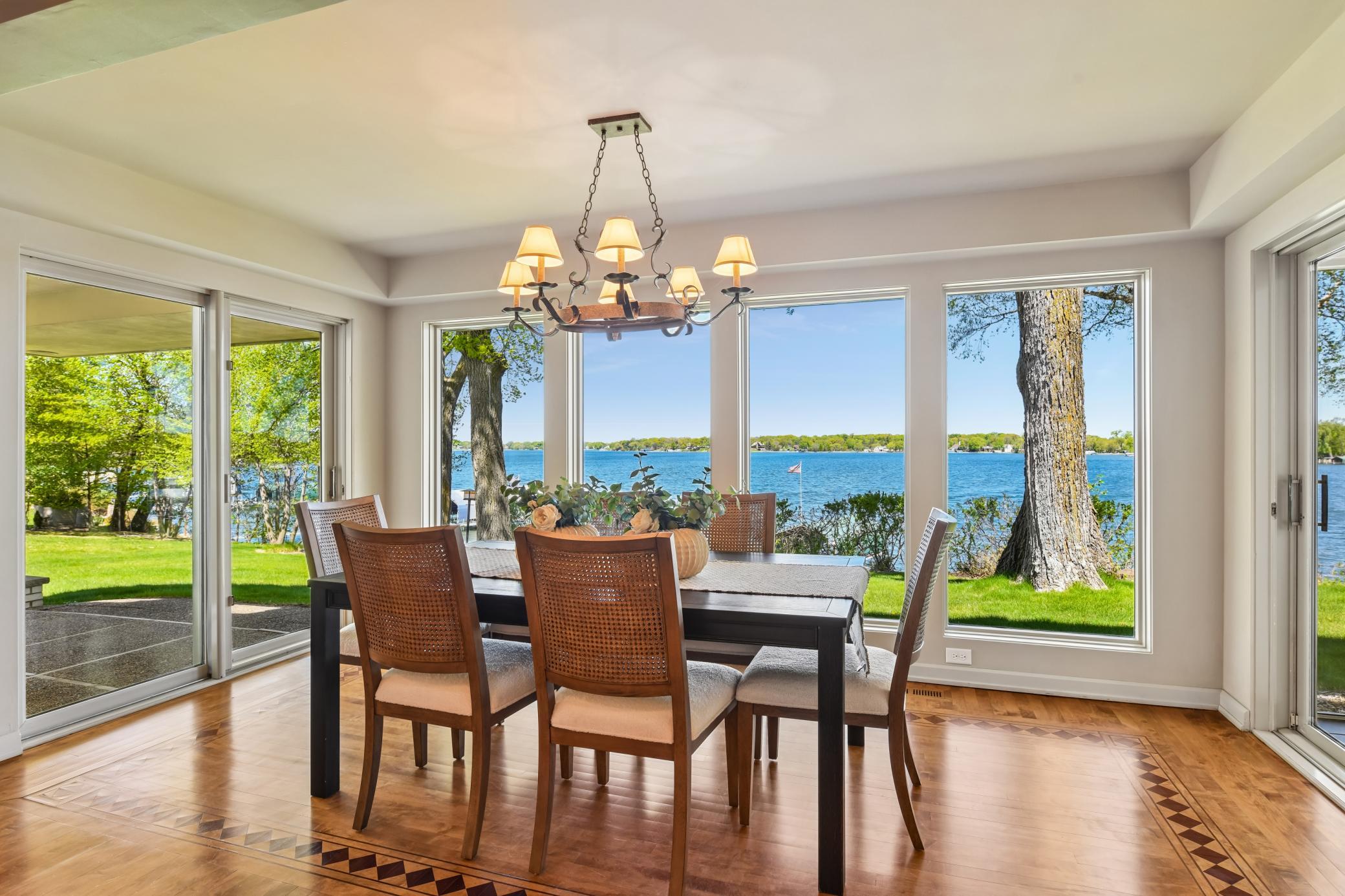 Spacious and offering access to the lakeside patio and screen porch, the dining area is wrapped in windows and lake views.