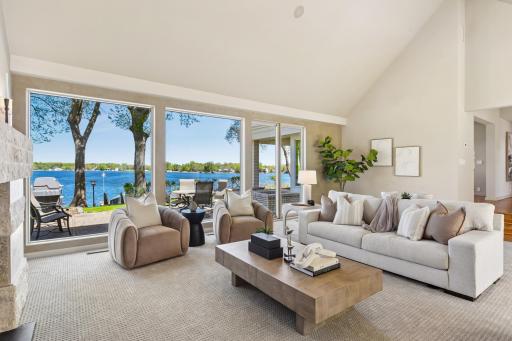 Perfect for gatherings and family moments alike, the living room exudes elegance with tall vaulted ceiling, cozy fireplace and walls of windows filling the room with natural light and serene views.