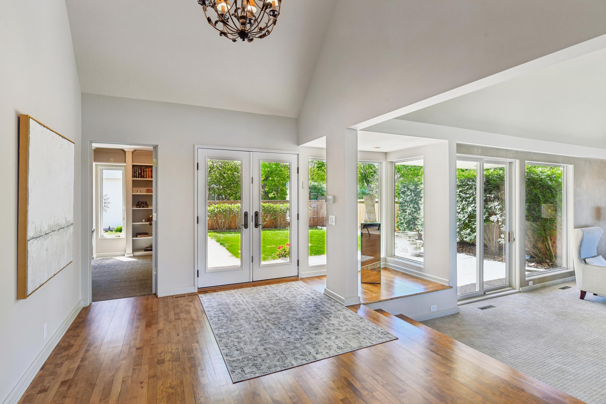 The spacious foyer showcases a vaulted ceiling and hardwood floors