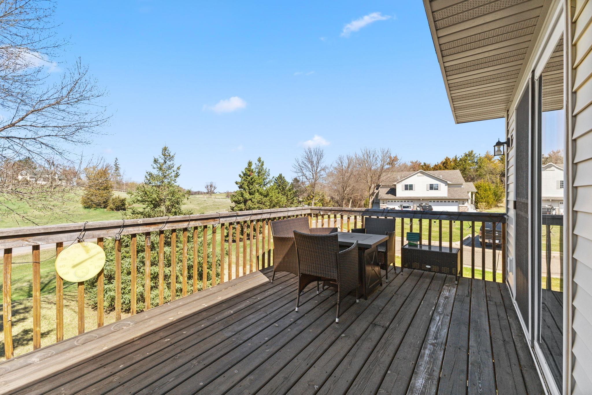 The deck measures roughly 22' x 10' and overlooks the rolling greenspace behind the unit.