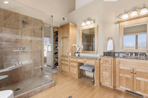 Primary bathroom features jetted tub, walk in shower with ceramic tile surround and large walk in closet with washer & dryer.