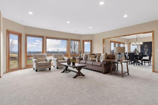 Lower level family room with walls of windows capture natures views! Endless entertainment spaces include a large amusement room & wet bar that make this home a great place to host gatherings!