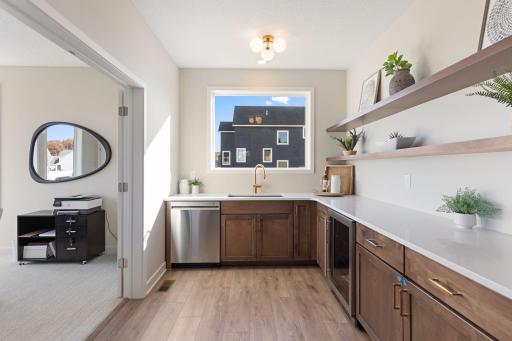 Butler's pantry with floating shelves and large window for natural light