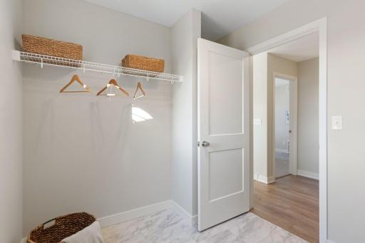Laundry room with shelving behind the door and wire shelf for drying clothes