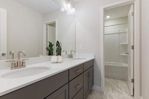 Hall bathroom with double sinks and separated tub/toilet area