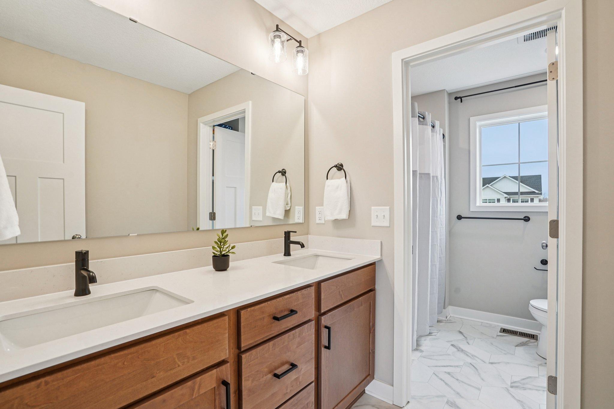 Upper level full bath with dual vanity and separate shower/toilet space.