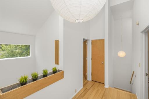 Overlook to living area below brings more light into upstairs hall
