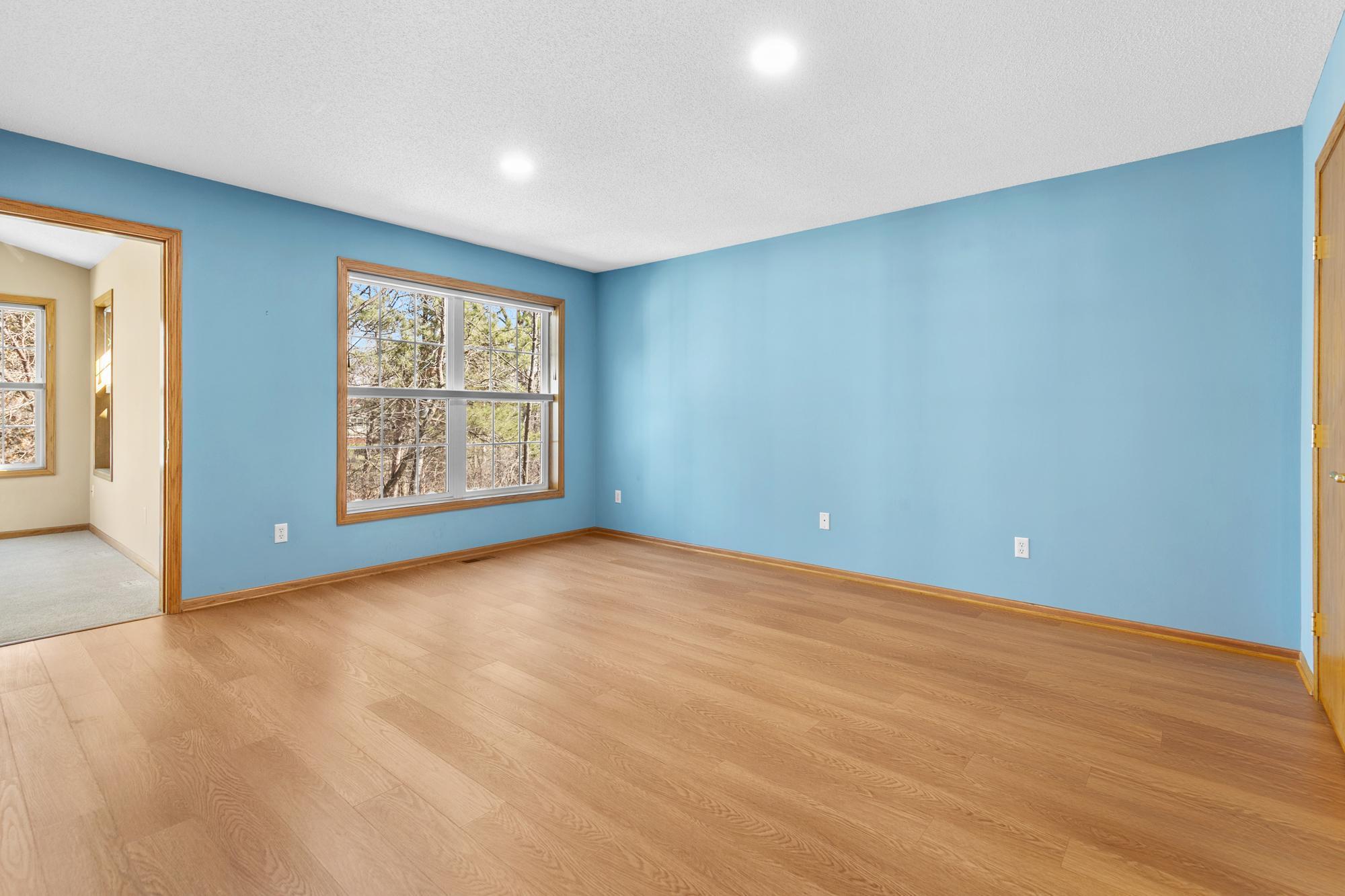 Primary bedroom with windows looking to wooded area in back yard