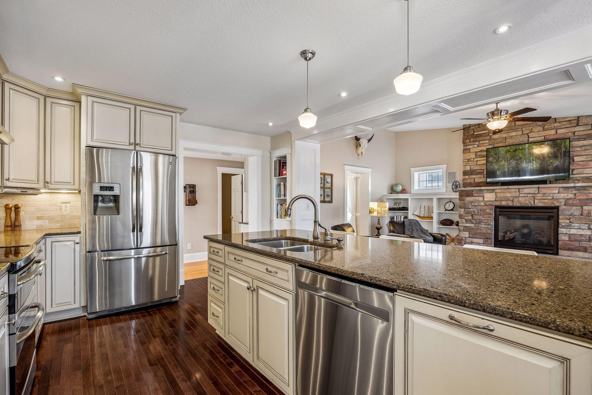 High-end design with gleaming hardwood floors, granite, tile backsplash and custom cabinets.