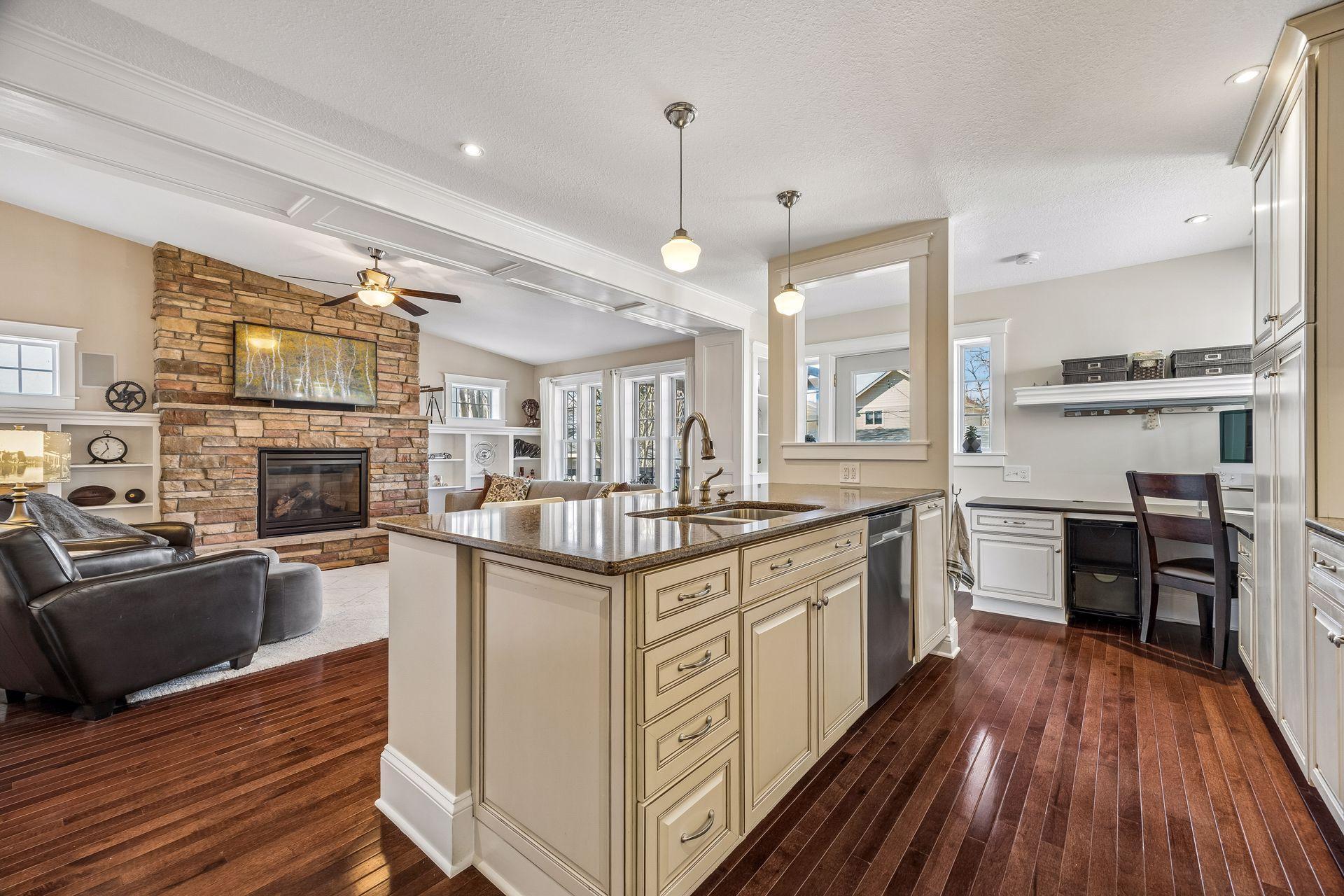 Open-concept kitchen with center island, abundant cabinetry, and seamless flow into the cozy family room with stone fireplace.