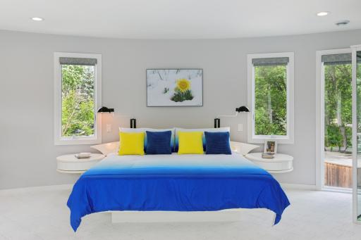 Primary Bedroom offers views of the lake from every window! Bedframe was custom built for the curvature of the primary wall and stays with the new homeowners!