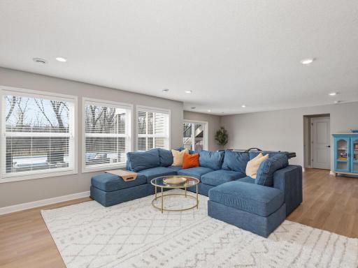 Bright walkout rec room with room for multiple setups—TV, gaming tables, or lounge areas. Seamless connection to back patio, pool, and yard creates a fun, flexible living space.