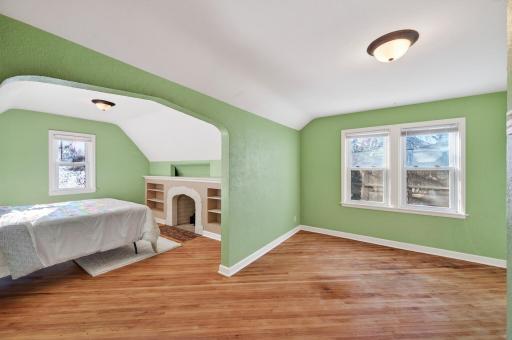 Upper level primary suite is anchored by a beautiful fireplace