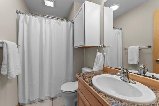 The primary bathroom has tile flooring and a vanity for convenient organization.