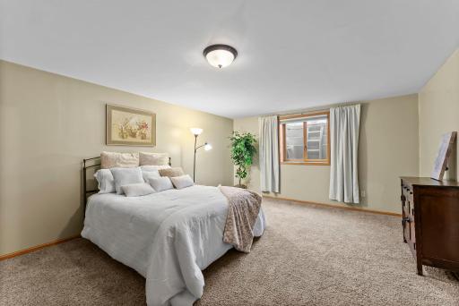 A well-sized fourth bedroom with comfortable carpeting and an added egress window provides a private guest retreat.
