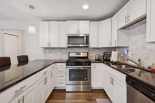 Gas stove and microwave, stone countertops, stainless appliance suite.