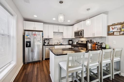 Kitchen with gas burner, stainless steel appliance suite, microwave and cabinetry.