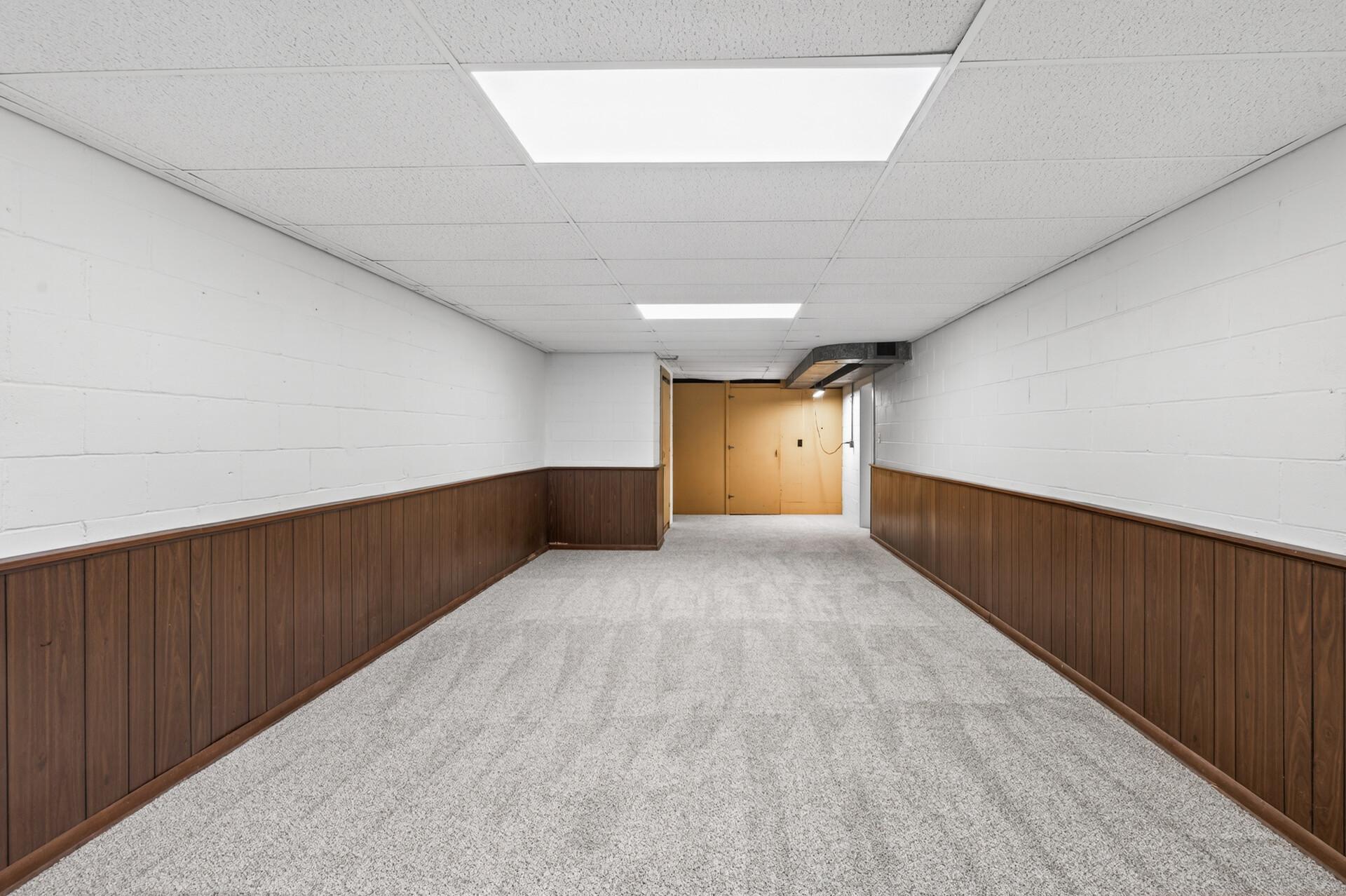 Another angle of the bonus space, door opens to a large unfinished work room or storage. There is also a built-in wine rack next to the door. Another separate door opens to additional storage.