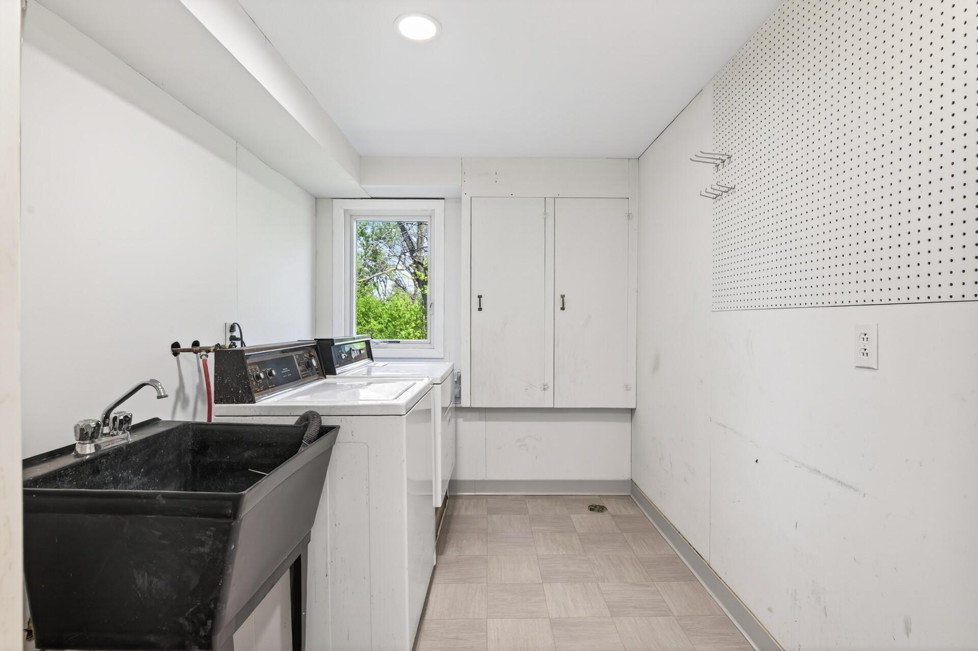 Lower level laundry room with utility tub, new flooring & fresh paint