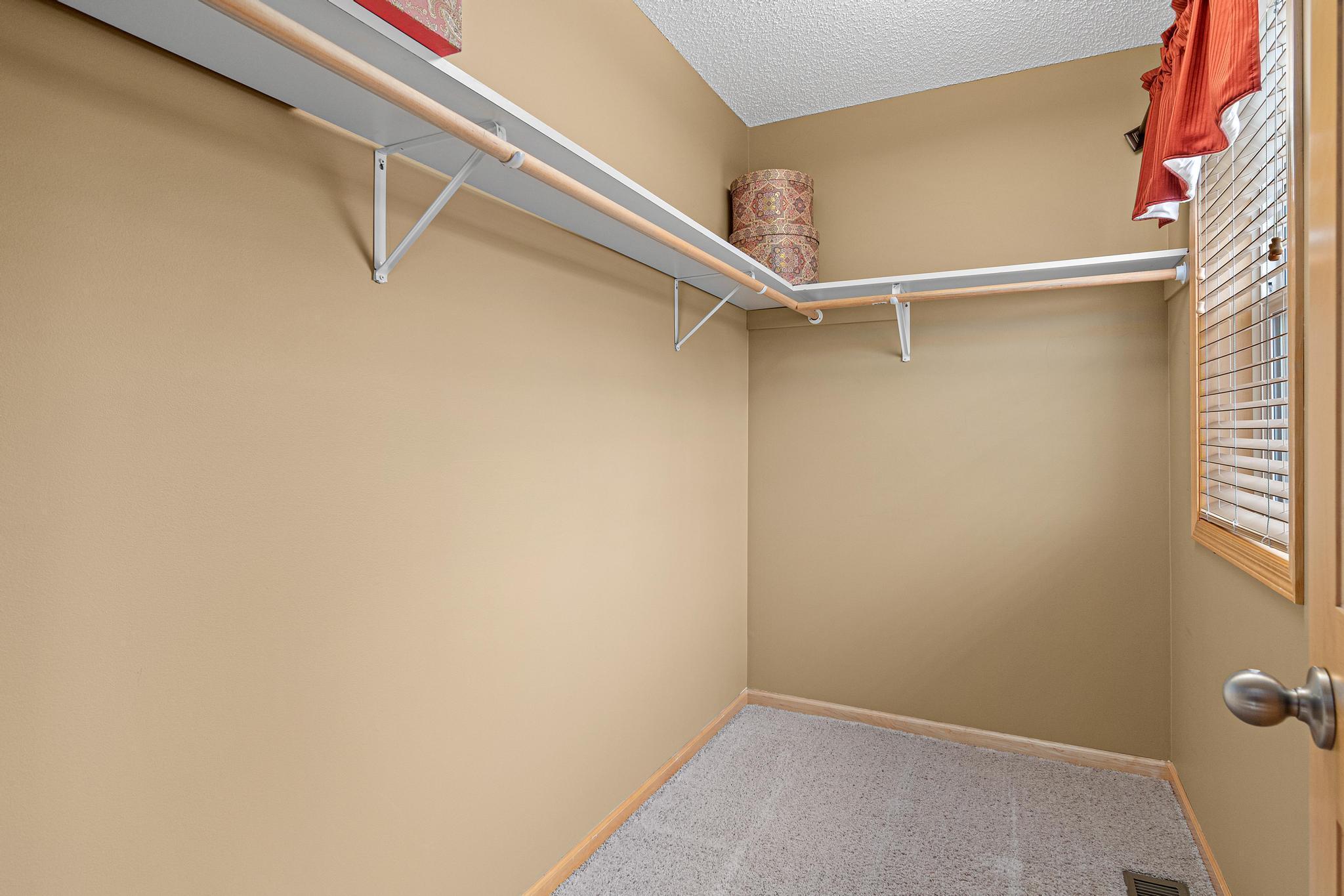 The primary bedroom closet is 1 of 3 sizable walk-in closets found in this home. The window brings in nice natural light.