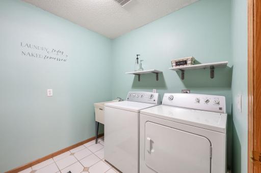 Main-level laundry with cabinets and counter space.