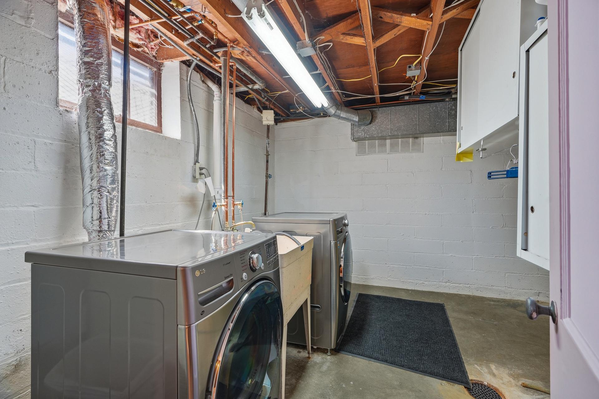 Stainless steel washer/dryer with a utility sink.