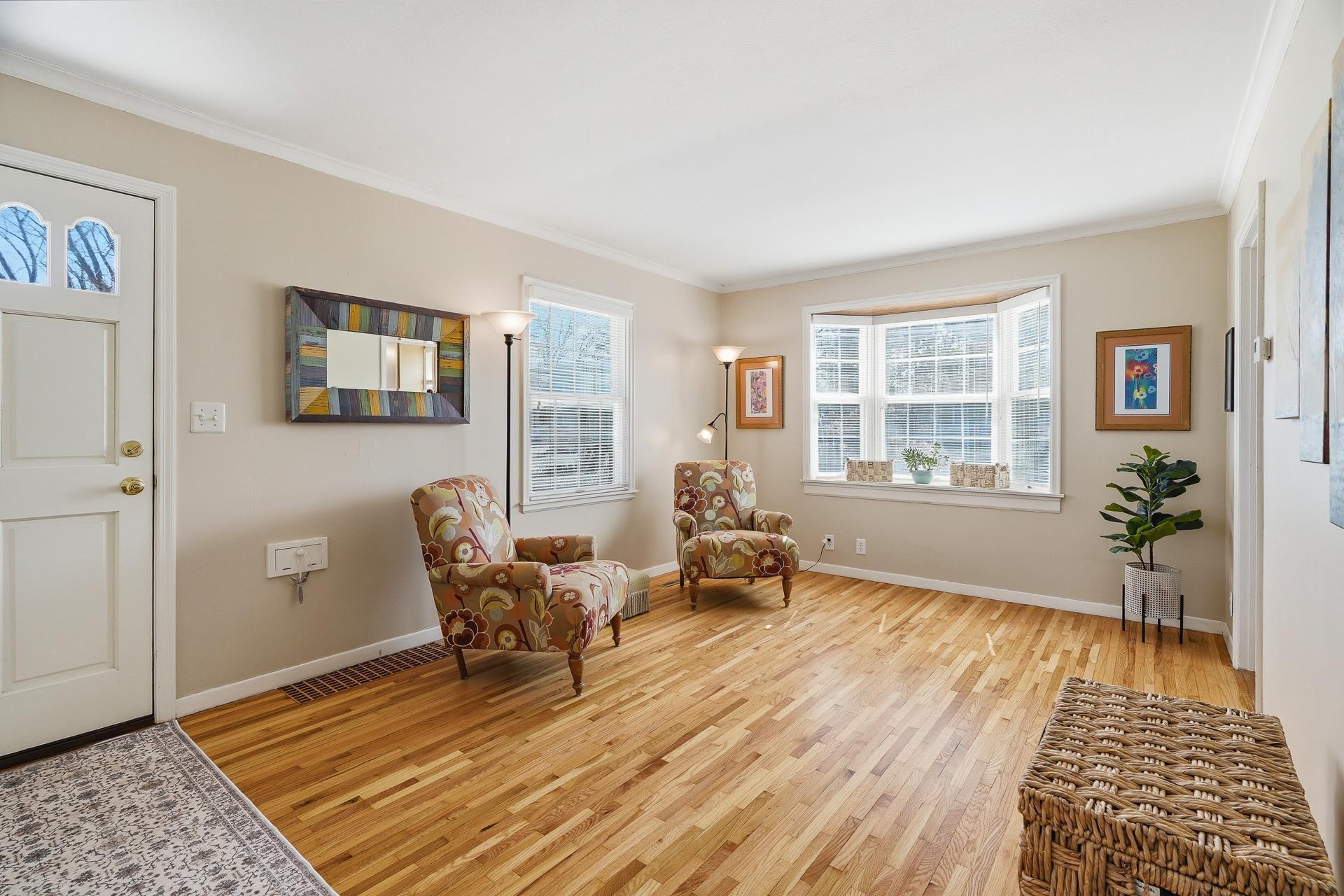 The living room features attractive hardwood floors, crown molding, and bay window with display ledge.
