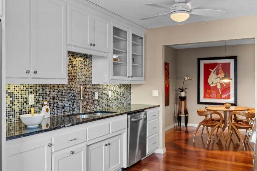 The kitchen features elegant white cabinetry and tiled backsplash.