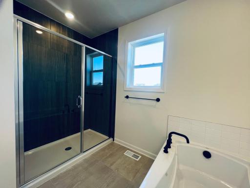 Walk-in shower with glass enclosure and tiled walls