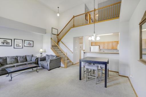 Freshly painted two story living room and dining room with open staircase.