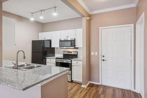 Freshly renovated kitchen with new countertops, backsplash, flooring, and fixtures