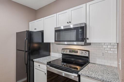 Freshly renovated kitchen with new countertops, backsplash, flooring, and fixtures