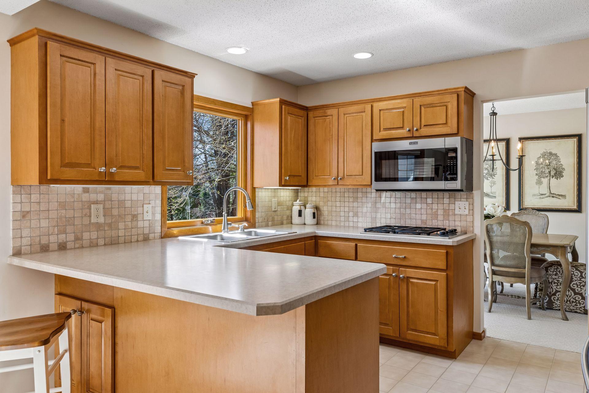 Sunny kitchen over looks peaceful back yard.