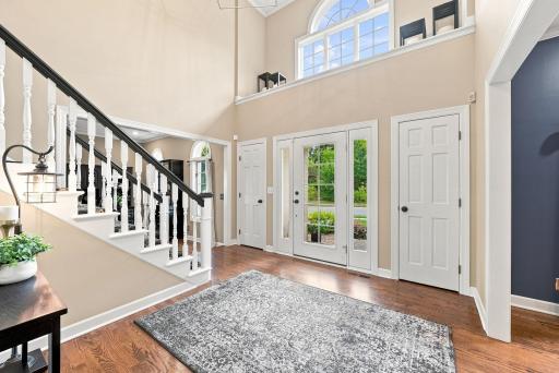 The front entry and foyer make a striking first impression with soaring two-story ceilings, a curved staircase, and French doors flanked by windows thich flood the space with natural light.