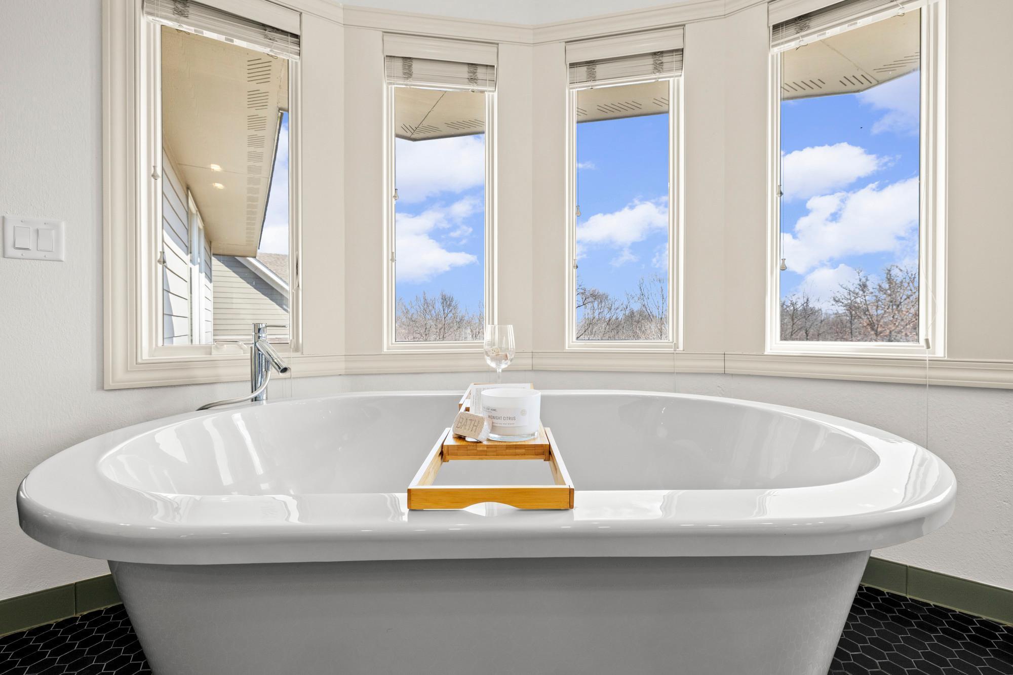 Freestanding tub framed by bay window