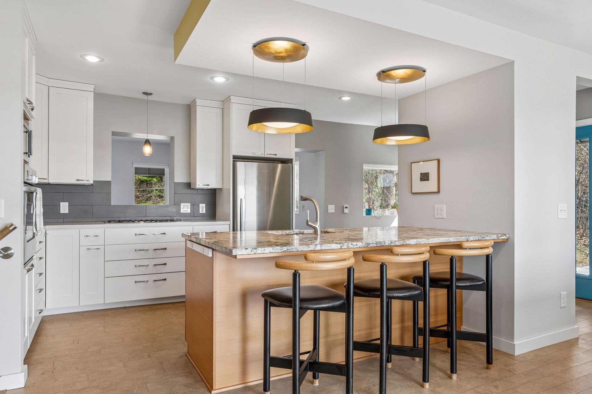 Fabulous breakfast bar with sink, custom cabinetry with pull out drawers, and top tier Fisher & Paykel stainless appliances.