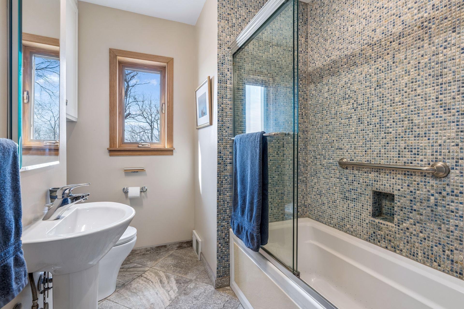 Fantastic full bath with fully tiled shower surround, jacuzzi tub, and granite flooring.