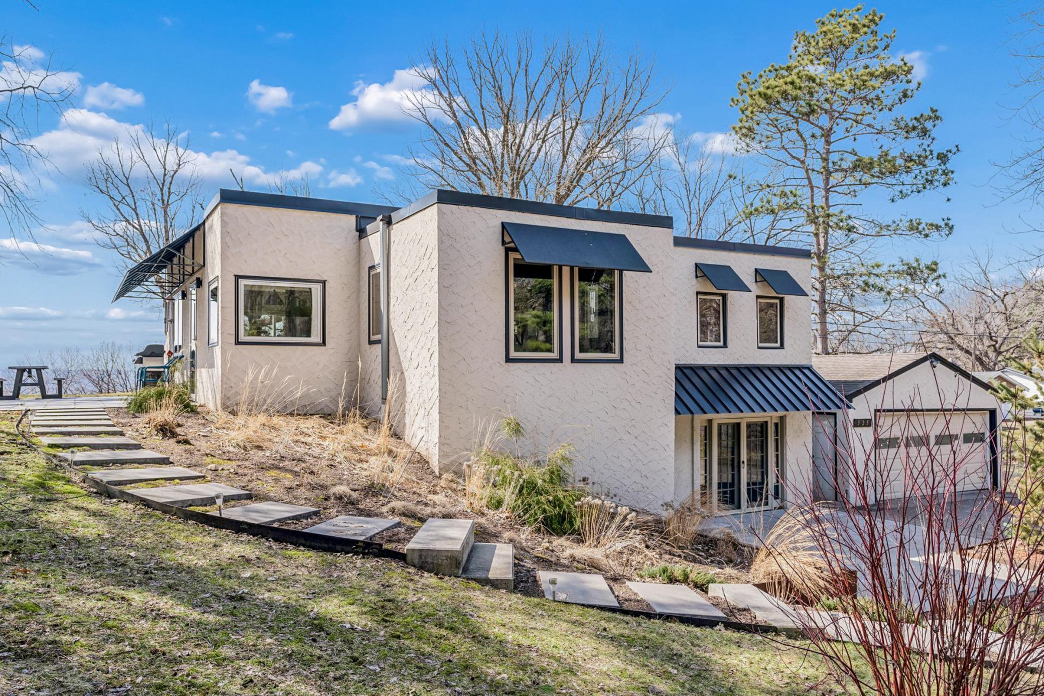 A perfect storybook setting for this unique, one-of-kind home nestled on an elevated lot overlooking Pigs Eye Lake! MILLION DOLLAR VIEW - only 3 homes have it, the neighbors to the south and this home!