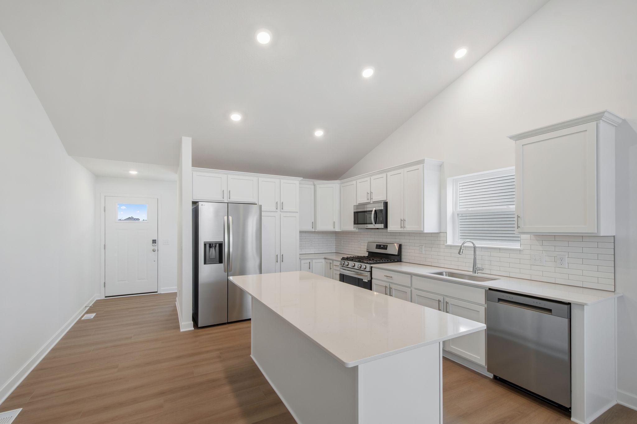 The stylish kitchen features an open layout with sleek cabinetry and an inviting center island, ready for creating chef-inspired recipes.