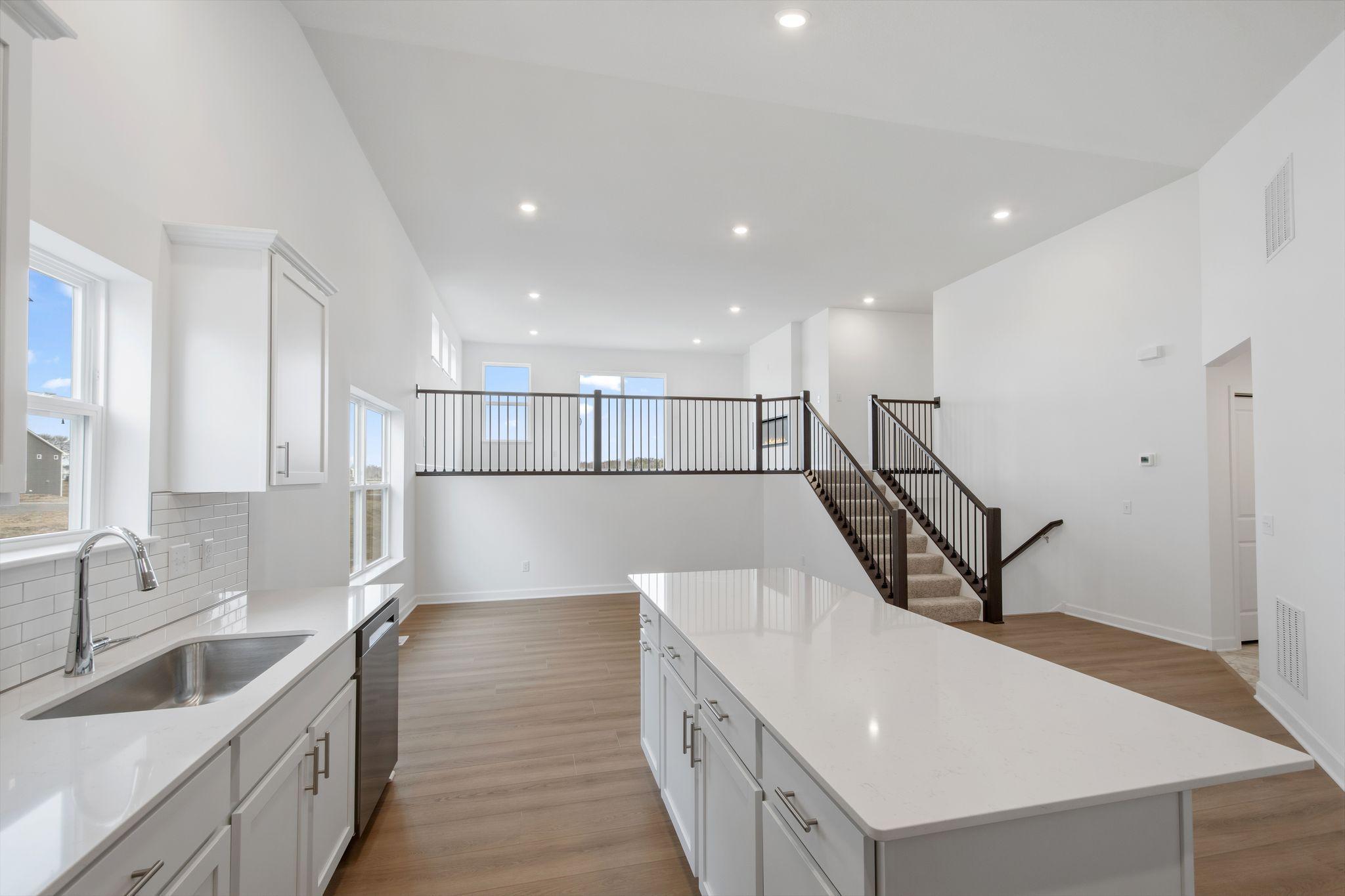 The undermount stainless steel sink with Moen® pull-out faucet is in easy reach of the modern dishwasher for quick clean-ups