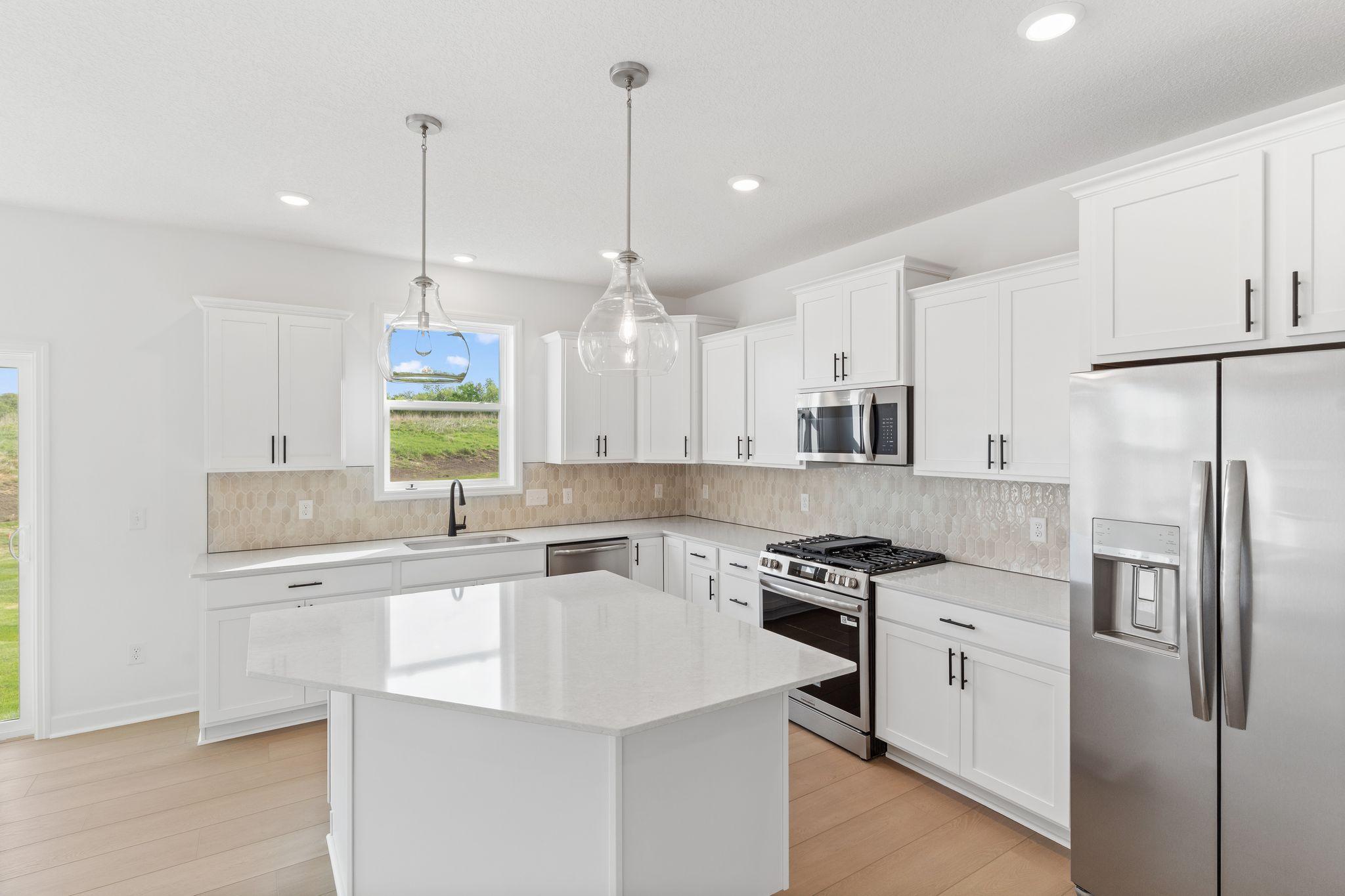 Designer-selected cabinets and quartz countertops frame the kitchen to provide cohesive style and functionality