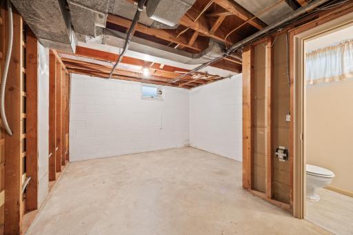 The area has been built out for a fourth bedroom with an egress window, where the original window is shown. The 1/2 bathroom on the right side of image has been built out with a full bath, tile surround bath alcove.
