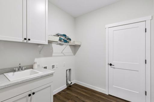 Laundry room complete with sink and storage