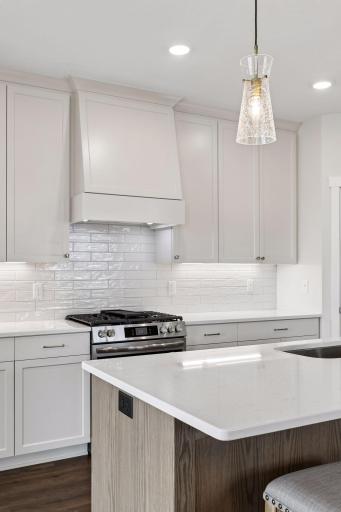 Decorative tile backsplash paired with custom cabinetry extending all the way to the ceiling for elegance