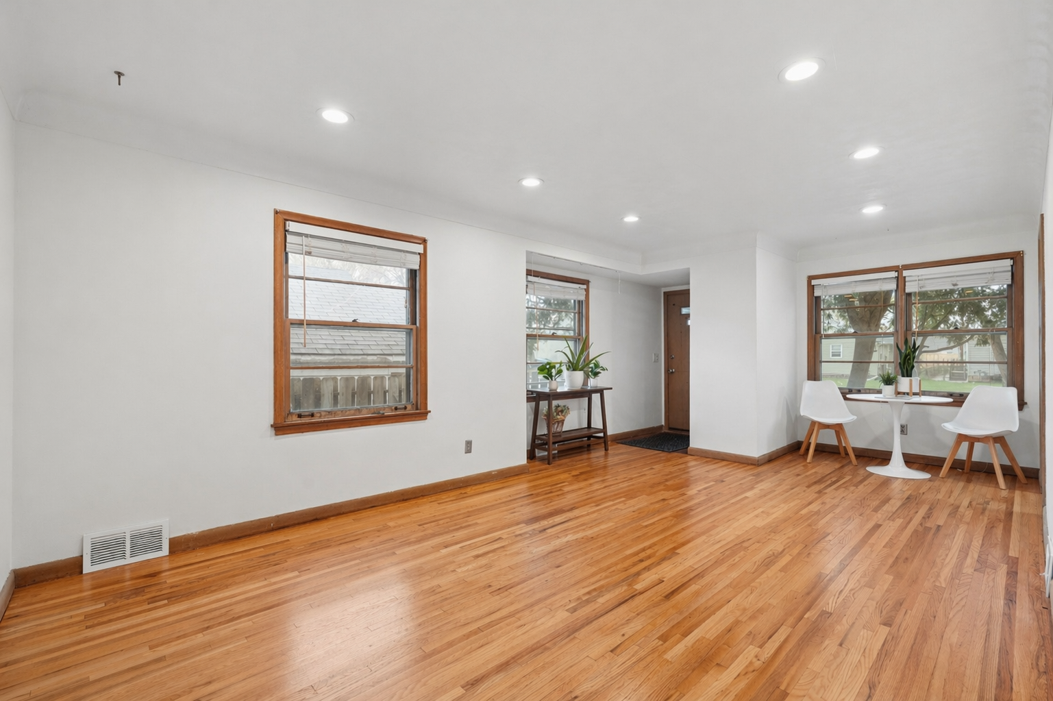 The main front entrance leads to a large living room with recessed lighting and plenty of space for a seating and a dining area