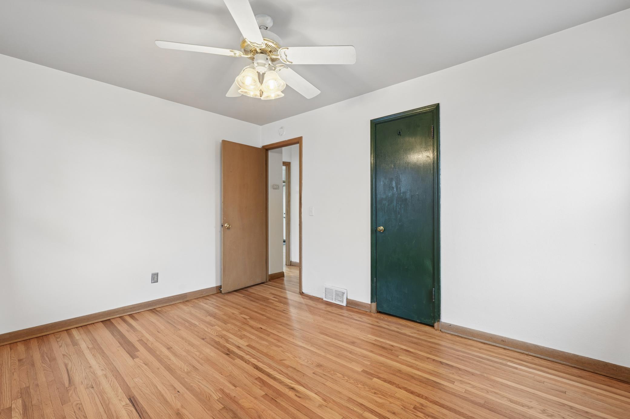 The second main level bedroom with a ceiling fan and colorful closet