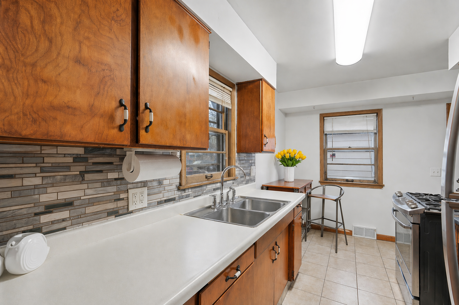 Double windows fill the kitchen with natural light and highlight a comfortable eat-in area
